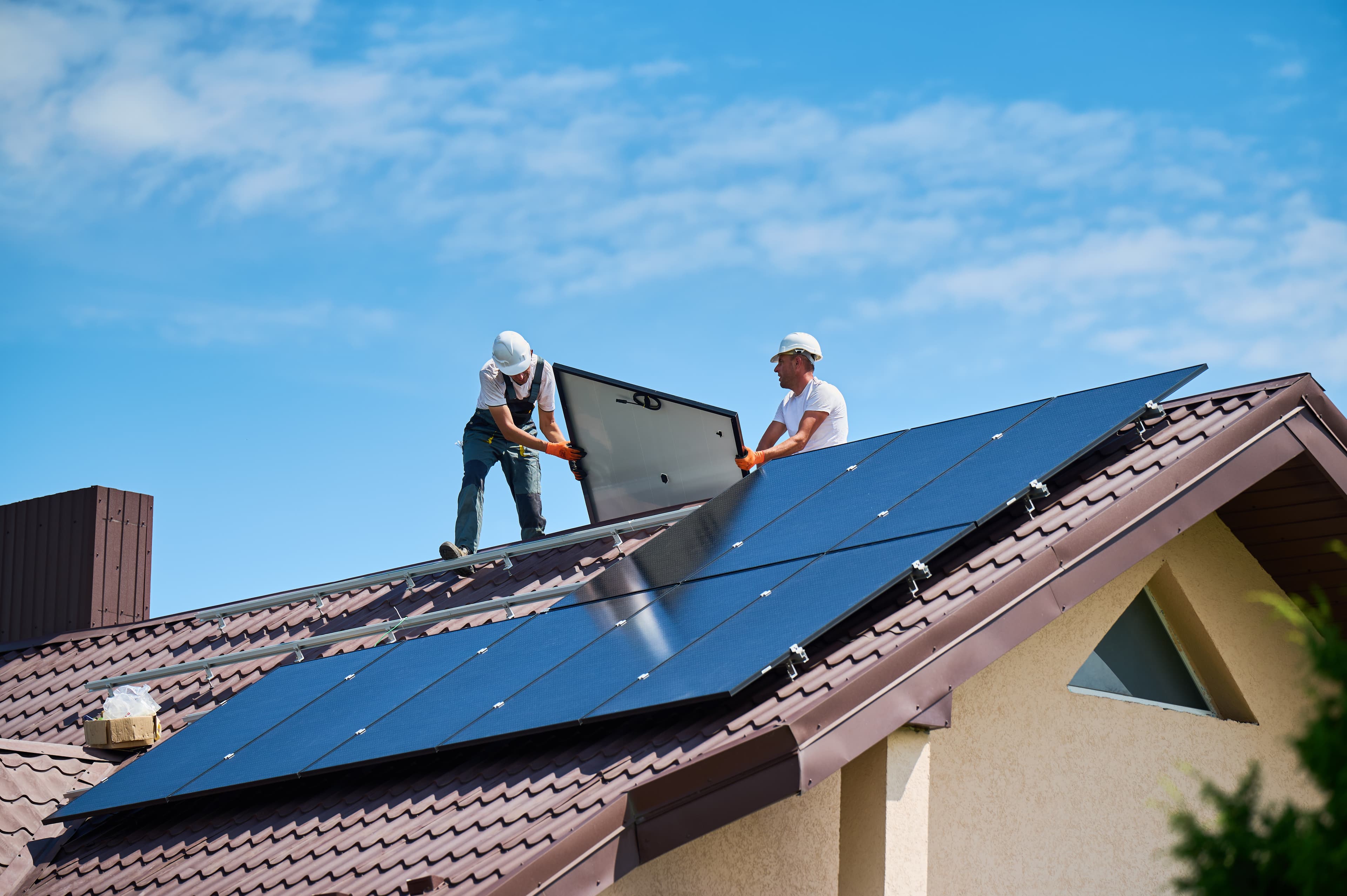 Équipe de pose sur toiture résidentielle avec panneaux solaires